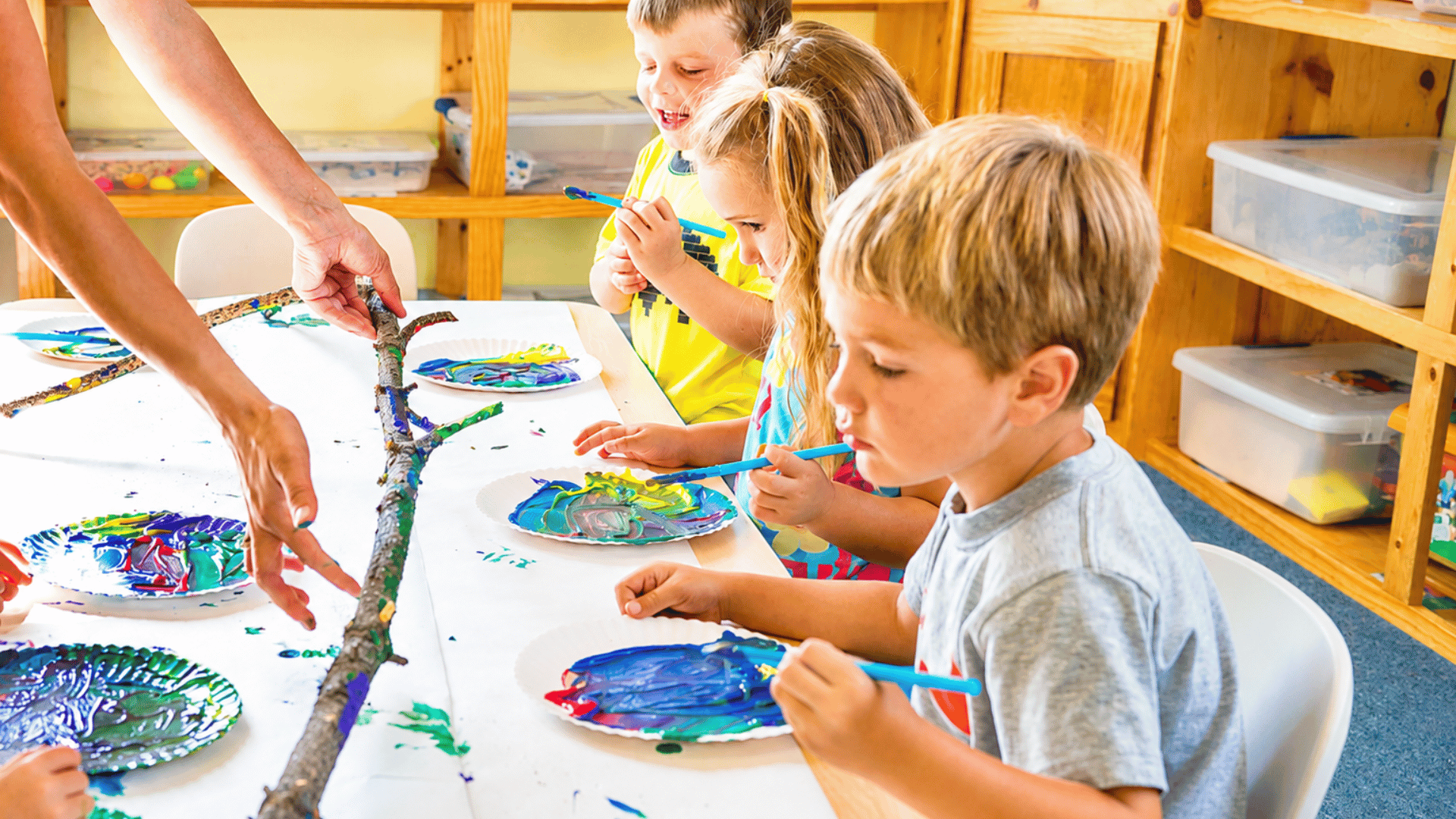 School-age kids painting at a classroom table at our 1st Street campus